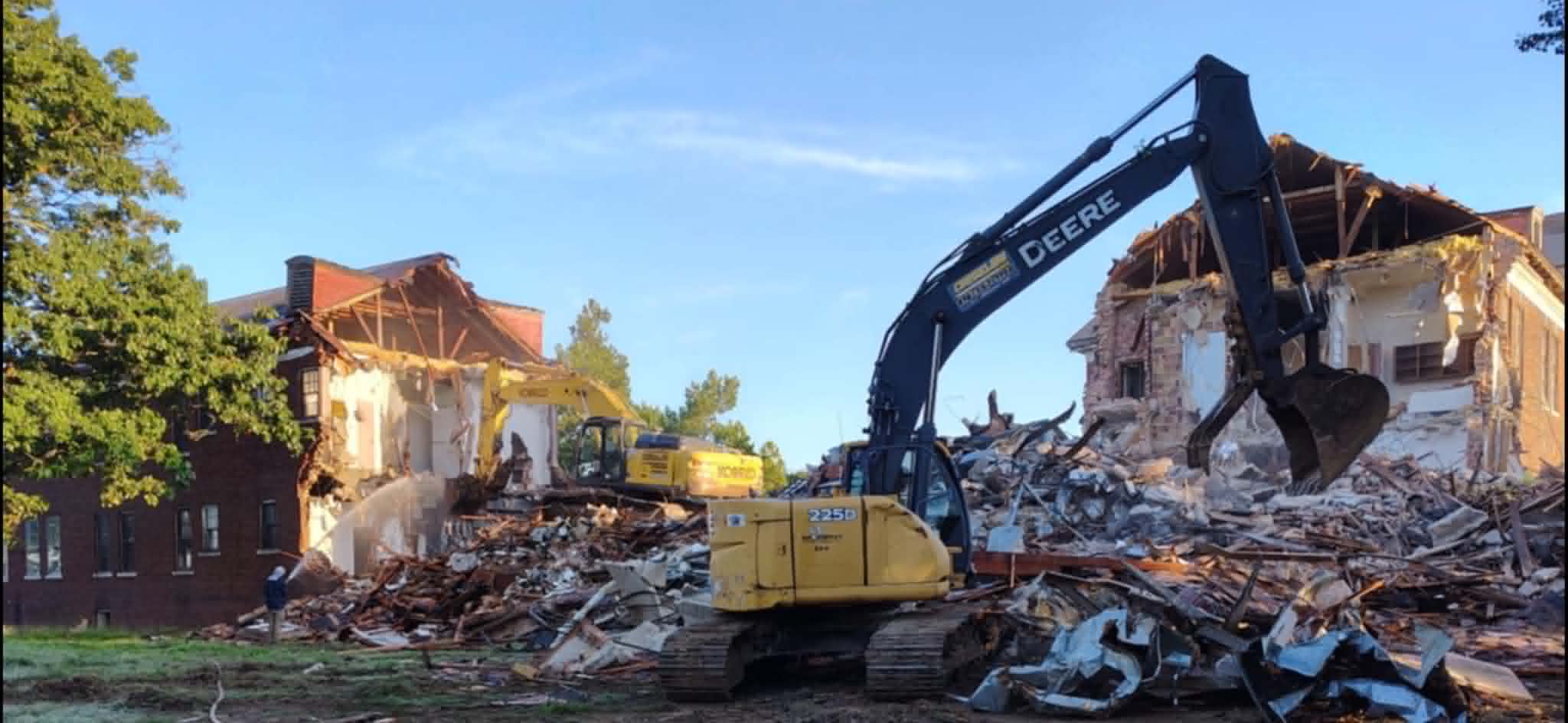 Excavator tearing into the historic brick building during demolition in Kansas